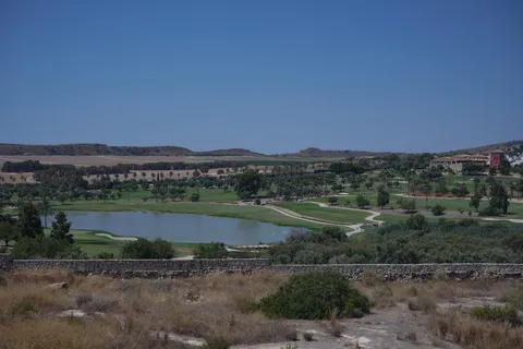 Vue depuis la villa témoin sur le golf de La Finca, avec son lac et les collines au loin